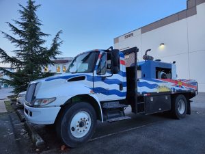 Commercial utility truck with custom blue and white fleet graphics and British Columbia themed design