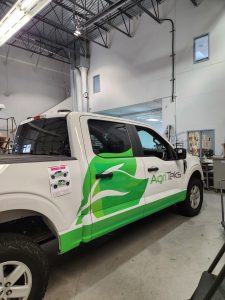 AgriTeks pickup truck with green partial wrap and commercial business graphics
